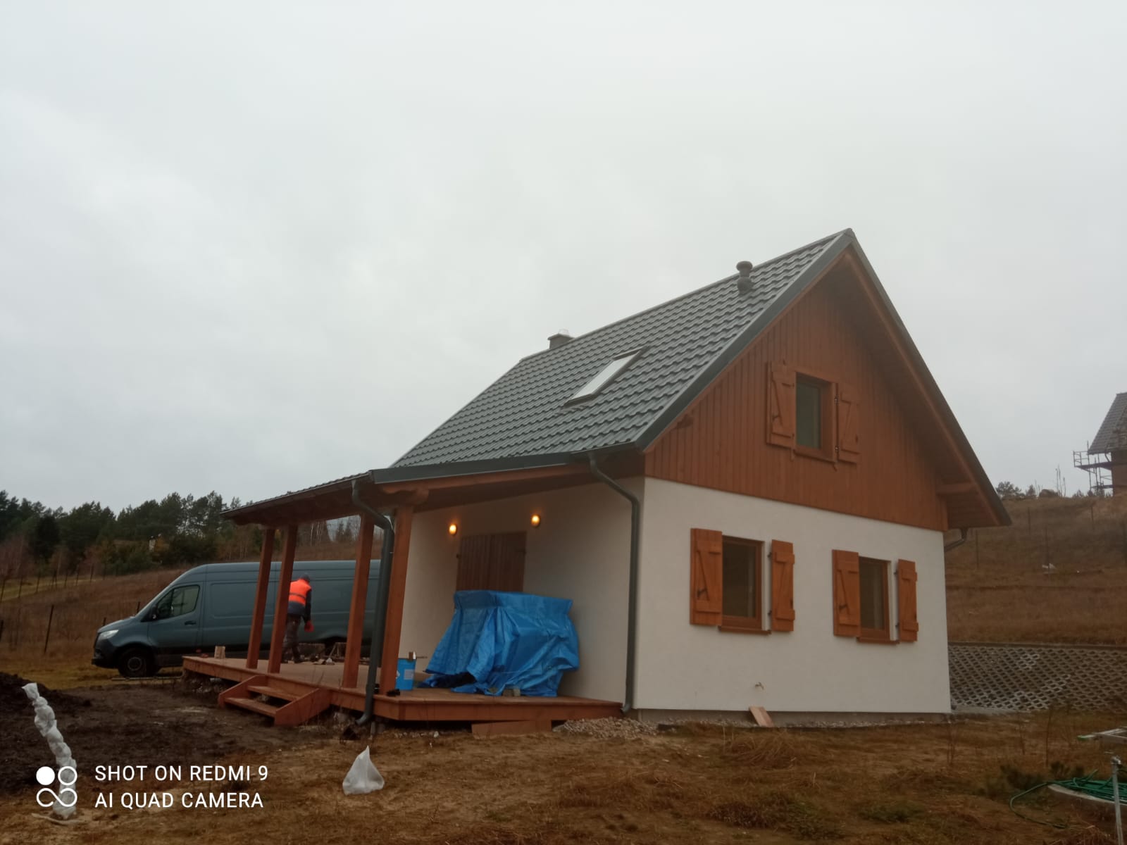 Dom szkieletowy — elewacja biała z drewnem, grafitowy dach